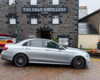 Silver Mercedes E-Class awaiting passengers for their travel to St Andrews outside Oban Distillery.
