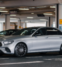 Silver Mercedes E-Class ready for executive airport pickup at Edinburgh Airport's drop-off area.