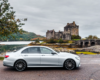 Silver Mercedes-Benz parked by the scenic Eilean Donan Castle on the route to St Andrews.