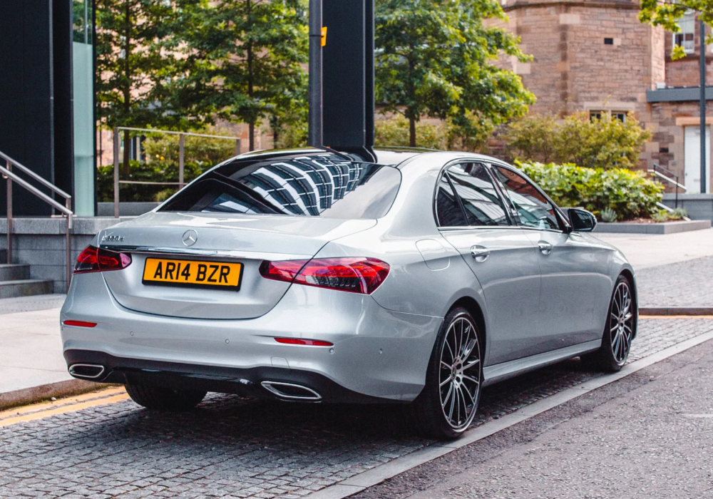 Silver Mercedes-Benz E-Class ready for an executive airport transfer on a city street.