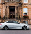 Silver Mercedes E-Class ready for executive transfers, parked outside a Glasgow hotel.