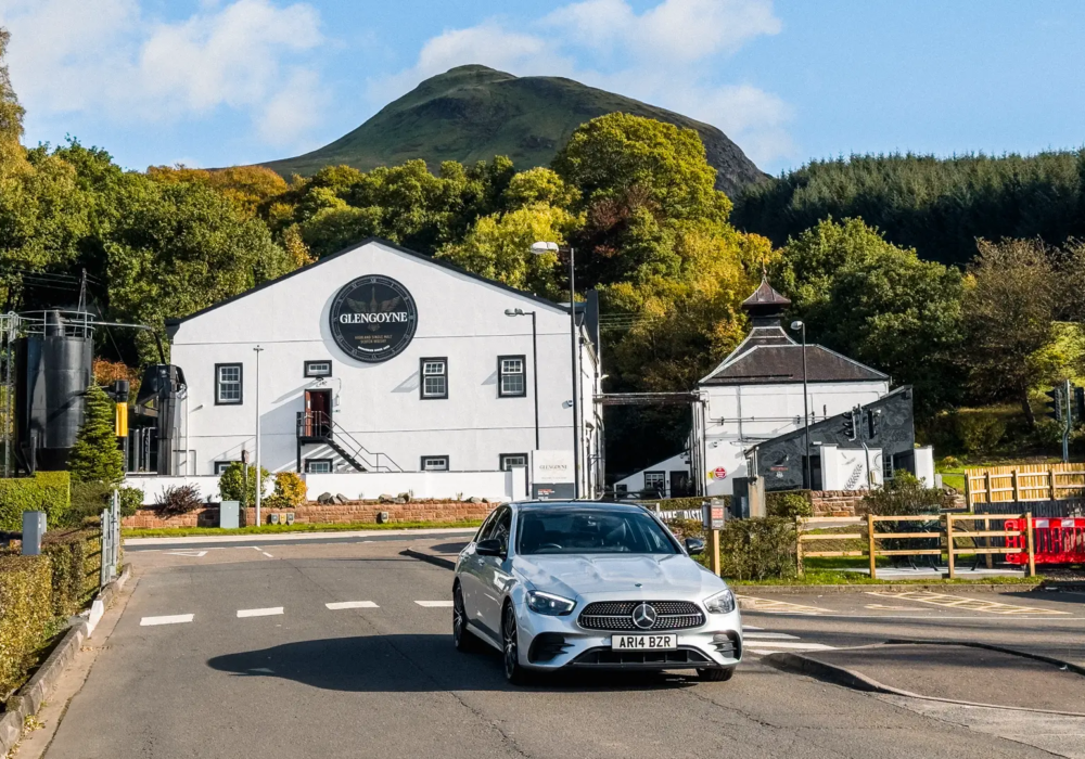 Silver Mercedes E-Class in front of Glengoyne Distillery, Scotland.