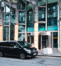 Executive airport-to-hotel transfer service with a black Mercedes V-Class van outside the Edinburgh International Conference Centre.
