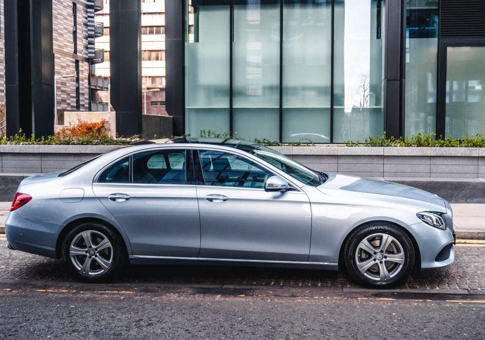 City-Ready Executive Transfer - Silver Mercedes-Benz E-Class Silver Mercedes-Benz E-Class parked on a city street, ready for hotel-to-airport transfers in Scotland.