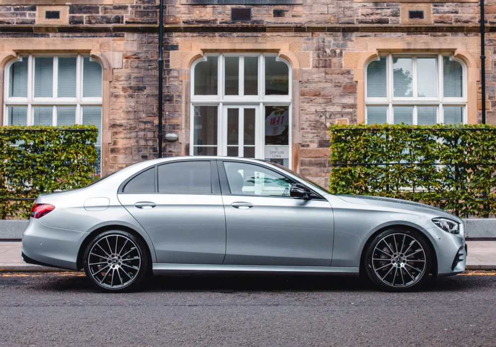 Silver Mercedes E-Class by a traditional Edinburgh hotel, ready for city transfers.