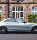 Silver Mercedes E-Class by a traditional Edinburgh hotel, ready for city transfers.