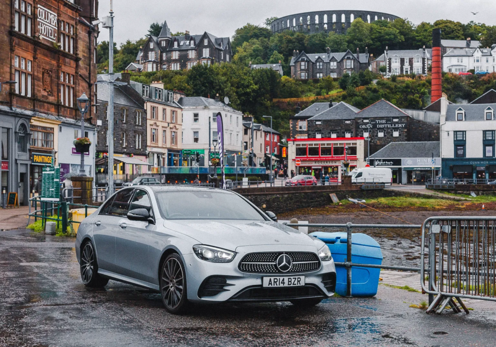 Mercedes E-Class ready for an executive transfer in Oban with the town's charming scene in the backdrop.