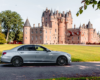 Mercedes-Benz E-Class ready for a scenic transfer, with Glamis Castle in the backdrop, on a private tour to St Andrews.