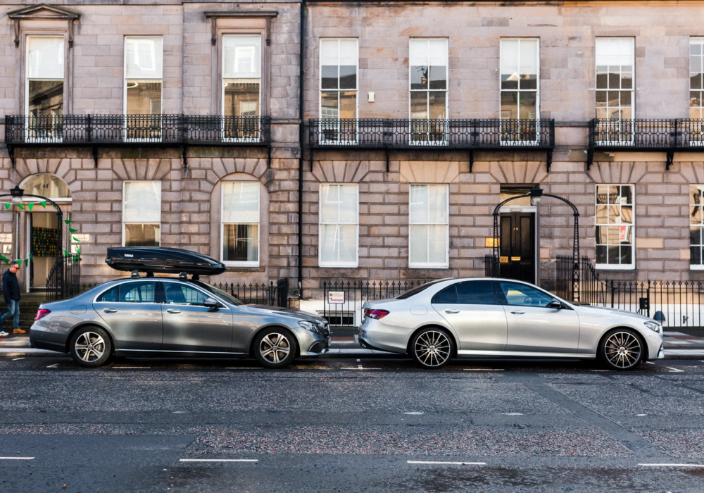 Grey and silver Mercedes-Benz cars ready for city tours, parked in historic Edinburgh.