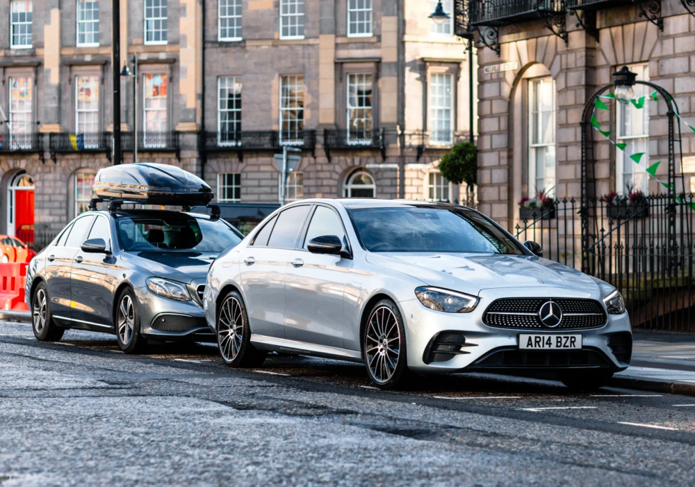 Grey Mercedes with rooftop box and silver Mercedes, side by side, ready for city-to-city travel and airport pickups in Scotland.